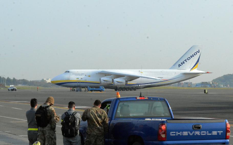 U.S. airmen watch an An-124 Antonov arrive at Yokota Air Base in western Tokyo, Wednesday, April 13, 2022.