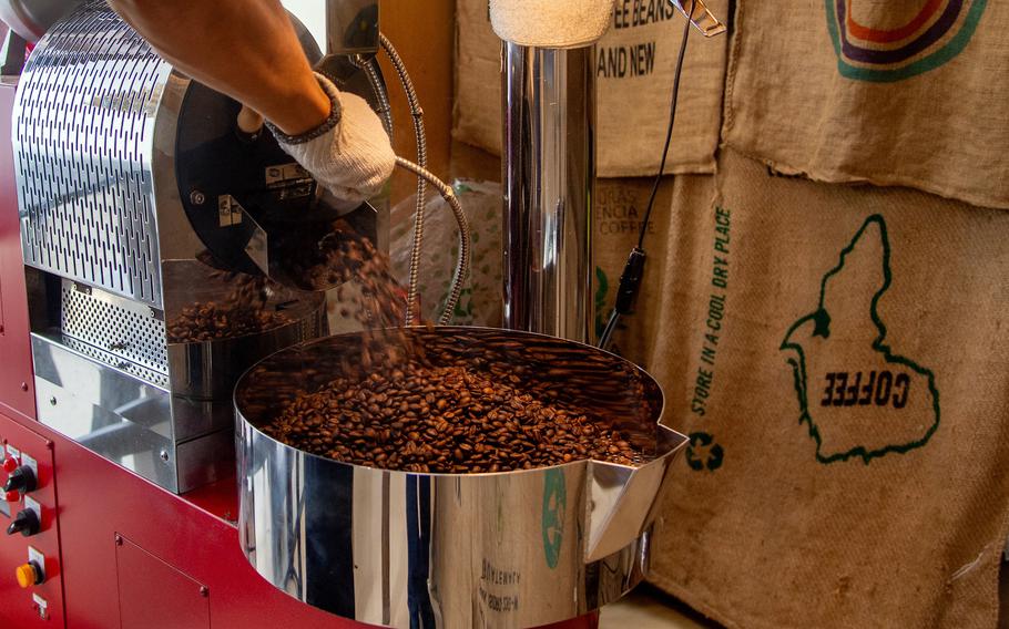 A worker empties a roaster at Matayoshi Coffee Farm on Okinawa, July 17, 2025.