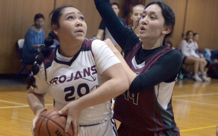 Zama's Deborah McClendon drives against Matthew C. Perry's Sophia Nye during Monday's Far East Girls Division II pool-play game, won by the Trojans 59-32.