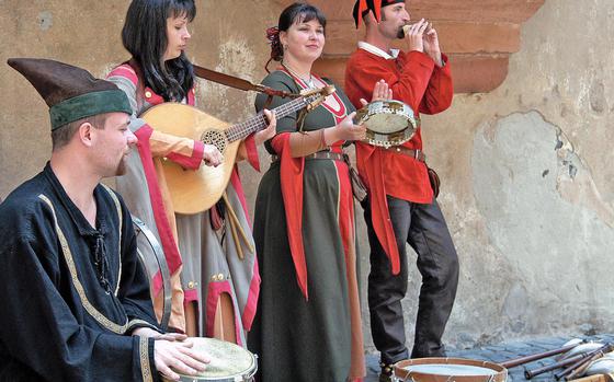 Minstrels dressed in period costumes, entertain at a medieval market