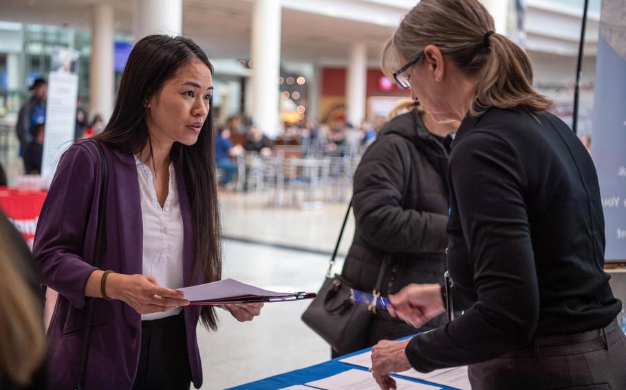 A military spouse looks over current positions available under the Direct Hiring Authority program at a job fair held at Ramstein Air Base, March 3, 2023. 
