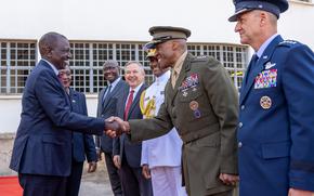 A politician shakes hands with a military official.