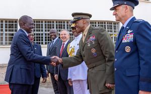 A politician shakes hands with a military official.