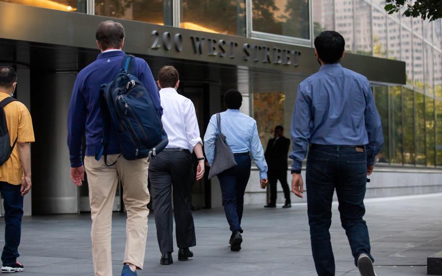 Office workers walk toward the Goldman Sachs headquarters in New York on July 22, 2021. 