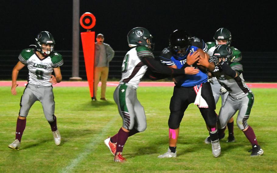 Versatile Hohenfels player Brian David carries the pile of AFNORTH defenders with him on a short catch and run in the first half of a football game against the AFNORTH Lions on Sept. 29, 2023 at Hohenfels Middle High School.