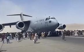 A video screen grab shows throngs of people running along side a U.S. Air Force C-17 preparing for takeoff at Hamid Karzai International Airport in Kabul, Afghanistan, on Monday, Aug. 16, 2021.