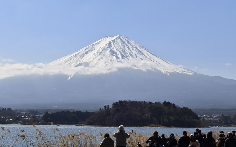 A snow-capped view of Mount Fuji from the banks of Lake Kawaguchiko in Yamanshi prefecture, Japan.