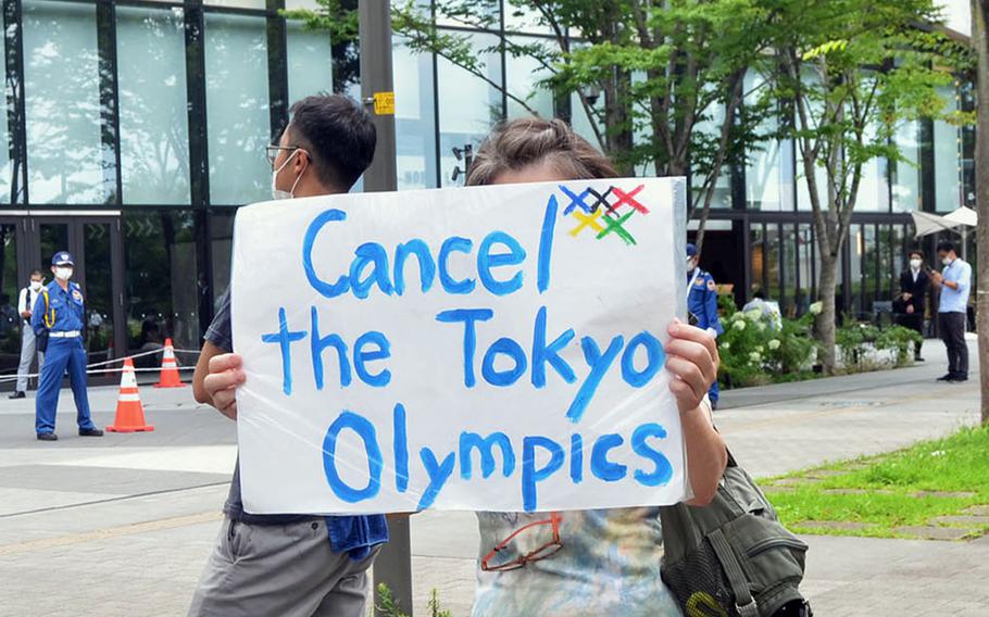 A handful of protesters call for canceling the Tokyo Olympics outside a private torch relay ceremony in Tachikawa, Japan, Monday, July 12, 2021. 