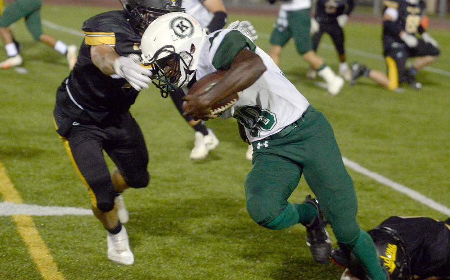 Kubasaki's Godfrey Wray, the game's leading ground-gainer, tries to elude the tackle of Kadena's Trent Fowler.