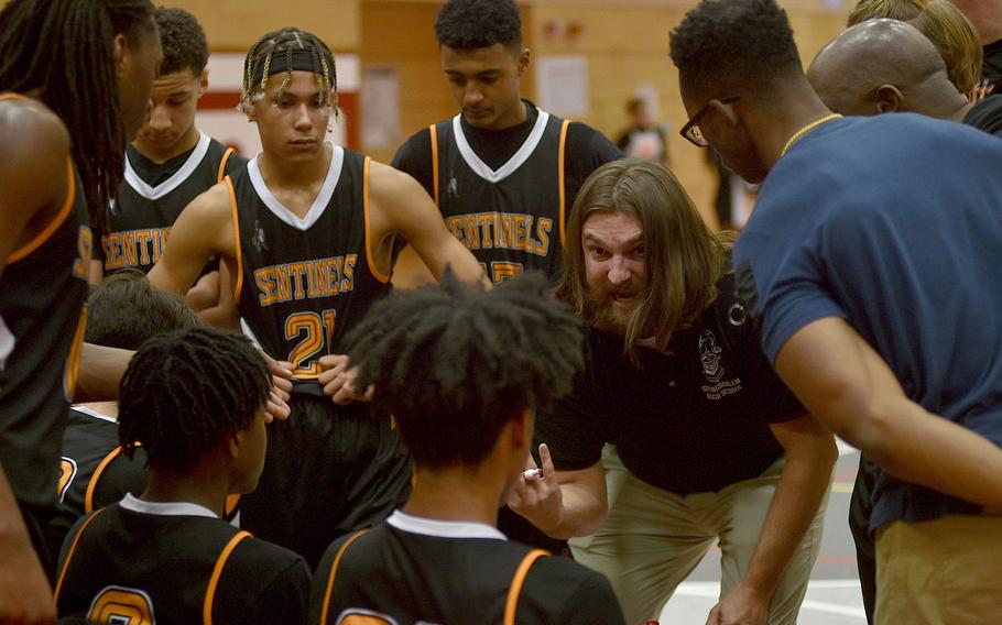 Spangdahlem coach Matthew Cirillo talks to the Sentinels on the bench between the first and second quarters during their game against the Raiders on Friday evening at Kaiserslautern High School in Kaiserslautern, Germany. The Sentinels won 51-46.