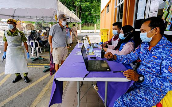Health workers register people to receive a dose of the Sinovec covid-19 vaccine at a vaccination center set up at the Pandamaran Sports Hall in Port Klang, Selangor, Malaysia, on May 20. Malaysia has secured access to enough coronavirus vaccines for its entire population, as the Southeast Asian nation prepares to roll out its inoculation program by the end of this month. MUST CREDIT: Bloomberg photo by Samsul Said