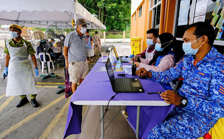 Health workers register people to receive a dose of the Sinovec COVID-19 vaccine at a vaccination center set up at the Pandamaran Sports Hall in Port Klang, Selangor, Malaysia, on May 20.