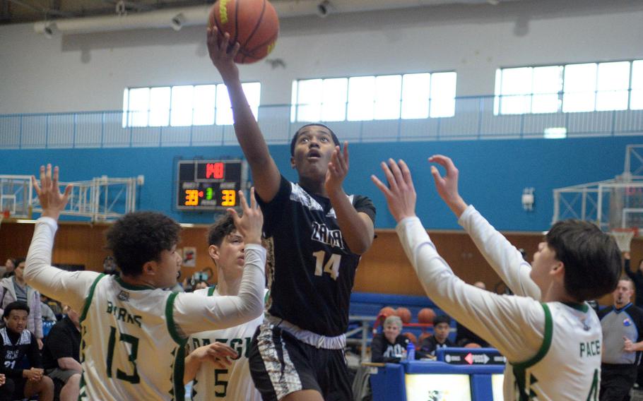 Zama's Derek Smith shoots between Daegu's Andrew Burks and Leo Pace. The Trojans won 65-61.