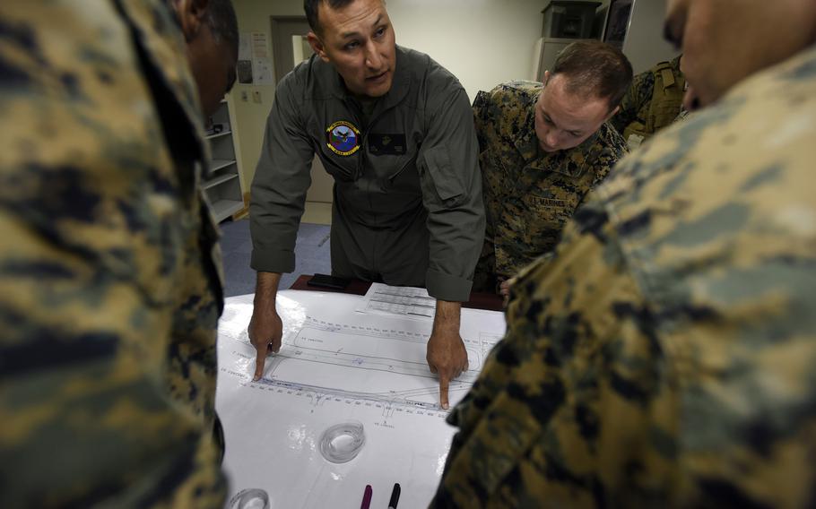 Marines discuss three possible ways to fix damaged areas of the flight line during an Active Shield exercise at Marine Corps Air Station Iwakuni, Japan, Oct 28, 2021.