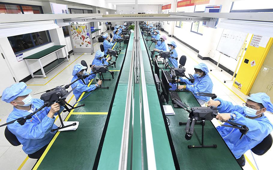 Workers produce drones at a factory in Wuhan, in China’s central Hubei province, April 13, 2023.. 