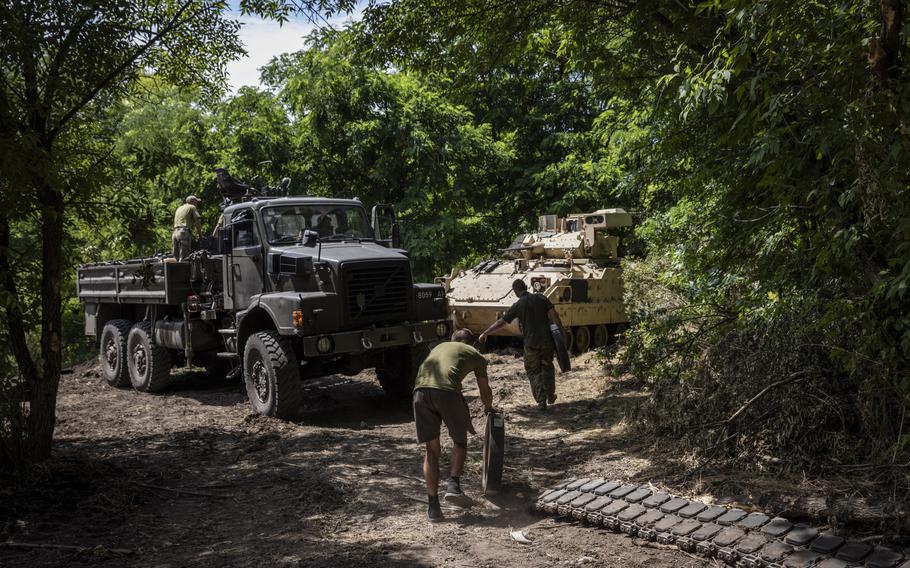 Personnel from Ukraine’s 47th Mechanized Brigade prepare to change wheels and tracks of a damaged Bradley Fighting Vehicle at the Zaporizhzhia workshop.