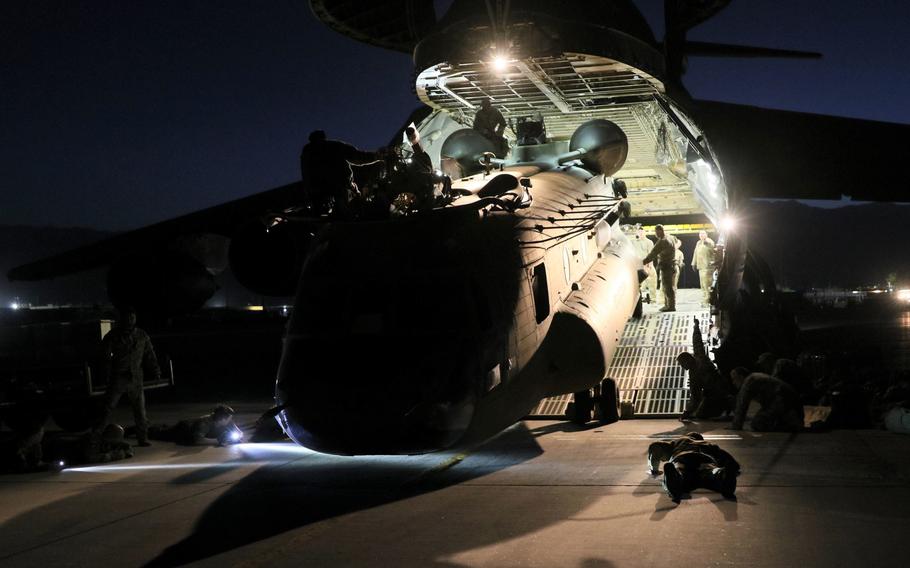 Aerial porters work with maintainers to load a CH-47 Chinook into a C-17 Globemaster III in Afghanistan, June 16, 2021. 