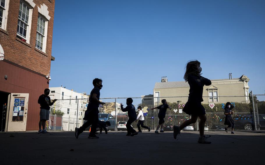 Students wearing protective masks exercise on the playground at an elementary school in San Francisco on Oct. 5, 2020. 