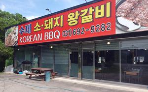 A huge sign in white letters announces “Korean BBQ,” in English, with words in Korean that translate to “handmade jumbo beef, pork galbi,” or ribs.