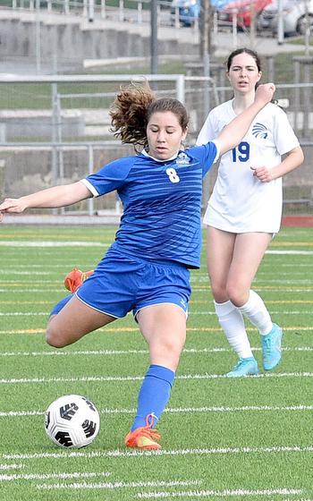 Ramstein's Julia Adkins prepares to launch a shot from distance during Saturday morning's match against Wiesbaden at Ramstein High School on Ramstein Air Base, Germany. Trailing the play is the Warrior midfielder Bridget Pidgeon.