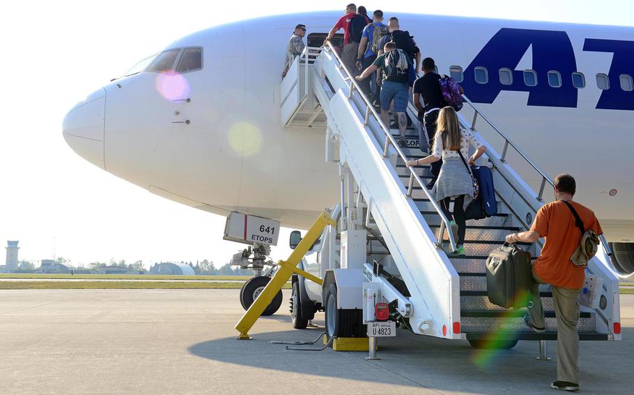 Airmen and their families board a plane at Aviano Air Base, Italy, in 2016. Because of the coronavirus pandemic, the Air Force is letting members accrue two months of extra leave to use over the next three years.