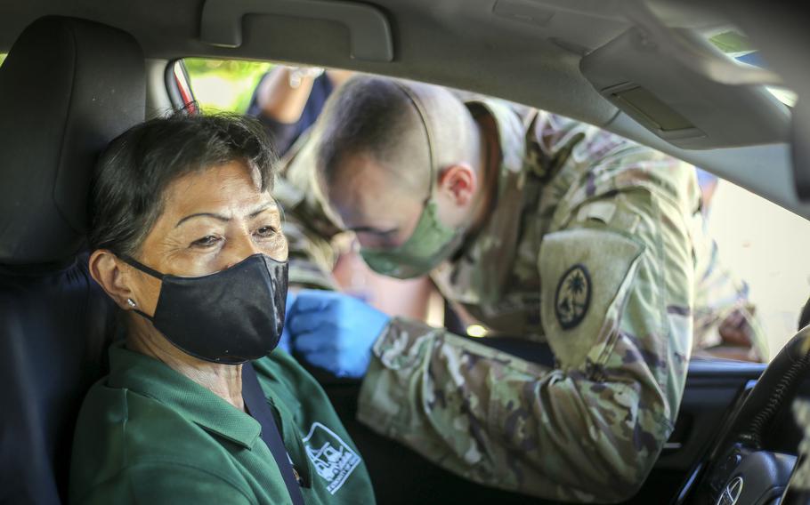 Spc. Michael Marsh, of the Guam National Guard, administers a COVID-19 vaccine to a member of the community at the Port Authority of Guam, June 2, 2021.