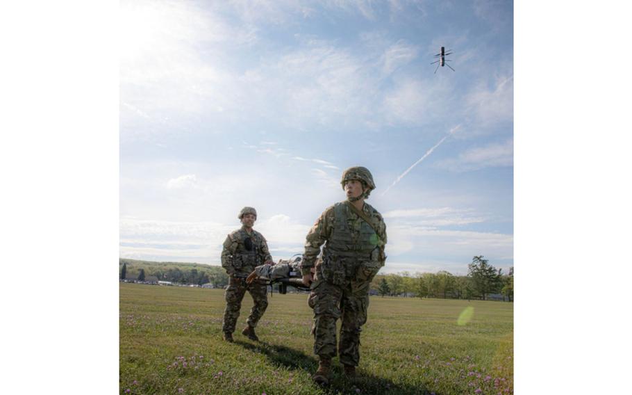 A medical drone watches over Iowa National Guard soldiers transporting a mock casualty during an exercise at Camp Grayling, Mich., Aug. 7, 2023.