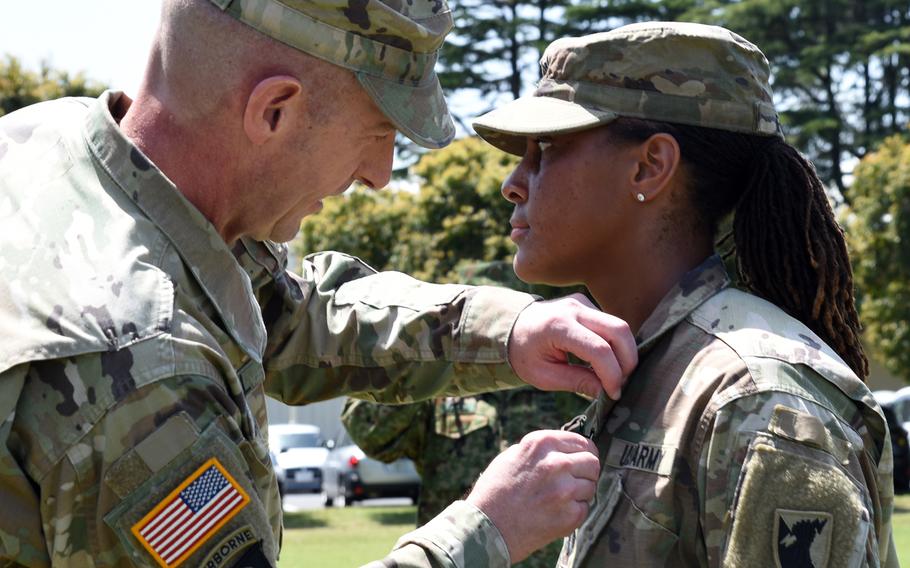 Capt. Quinetta Forby, 30, receives the Expert Soldier Badge from the commander of U.S. Army Japan, Maj. Gen. Joel B. Vowell, at Sagami General Depot, Japan, Friday, April 22, 2022. 