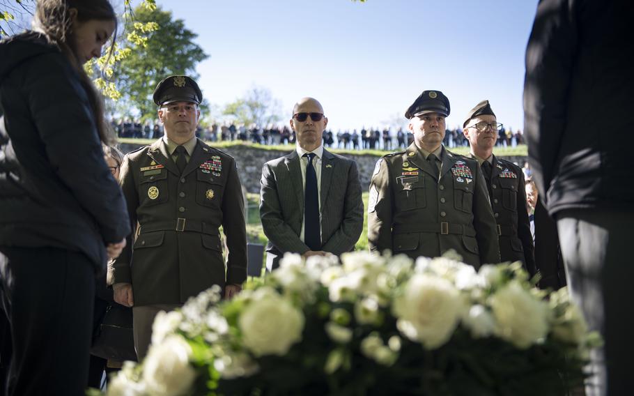 Soldiers stand in front of a memorial