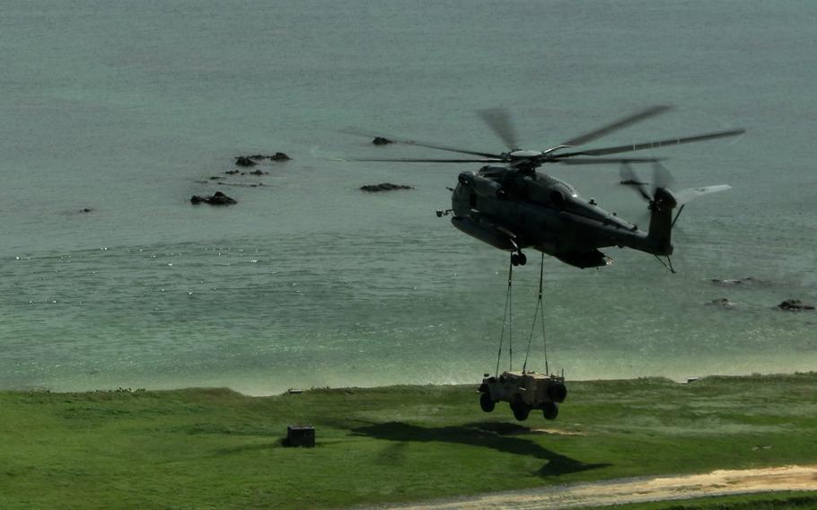 A CH-53E Super Stallion from Marine Medium Tiltrotor Squadron 262, bound for the USS Miguel Keith in the Philippine Sea, picks up a joint light tactical vehicle near Camp Hansen, Okinawa, Aug. 8, 2022.