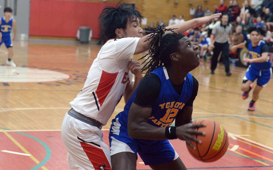 Yokota's Jai Bailey tries to shoot against E.J. King's Shan Casimiro during Friday's DODEA-Japan boys basketball game. The Panthers won 72-70.