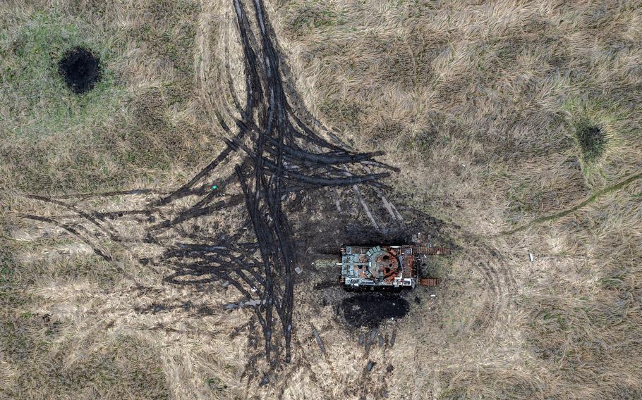 Artillery and mortar craters pierce the ground next to a destroyed Russian tank, on Oct. 23, 2022, in Kam’yanka, Kharkiv oblast, Ukraine. Ukraine’s president Volodymyr Zelenskyy has accused Russia of launching a massive attack on his country’s energy grid causing around 1.5 million households to be left without electricity.