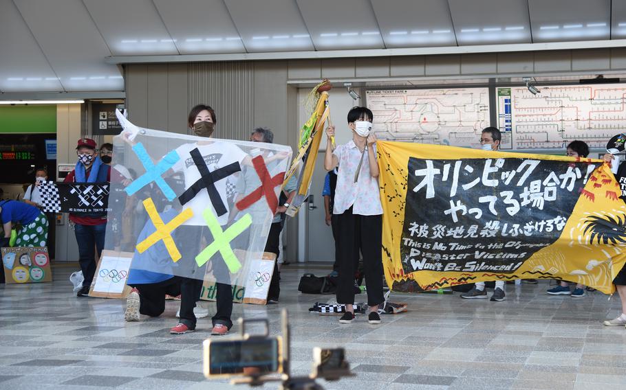 Anti-Olympics protesters hold up banners near National Stadium just hours before the official start of the Tokyo Games, Friday, June 23, 2021.