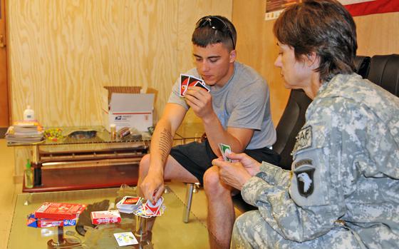Spc. Michael Ossa of Newark, Ohio, Headquarters and Headquarters Company, 1st Battalion, 327th Infantry Regiment, Task Force Bulldog, who was injured in a blast, teaches Maj. Priscilla Bejarano of San Antonio, Texas, Company C, 426th Brigade Support Battalion, m-TBI clinic officer in charge, how to play Uno July 1. TF Bastogne opened a Mild Traumatic Brain Injury Clinic mid-June at Forward Operating Base Fenty, Afghanistan. The Clinic assist blast casualties in recovering from potential brain injury by utilizing a variety of activities to address cognition, memory, balance, coordination, proprioception (the ability to unconsciously perceive movement and spatial orientation) and the ability to perform their jobs.