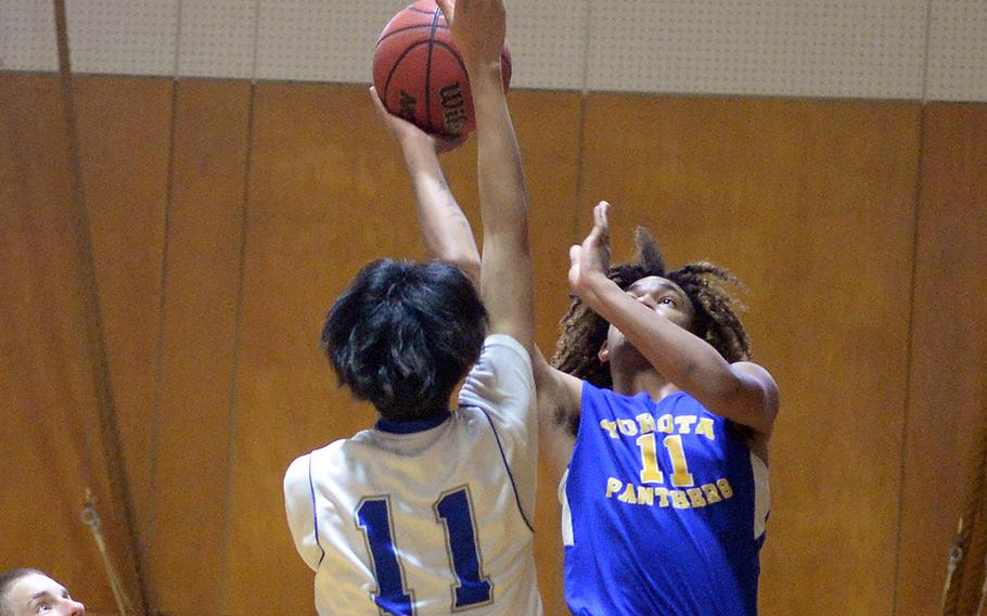 Yokota's Damian Abrams puts up a shot against Christian Academy Japan's Josh Jullian during Thursday's pool game in the 5th American School In Japan Kanto Classic basketeball tournament. The Panthers won 46-23.