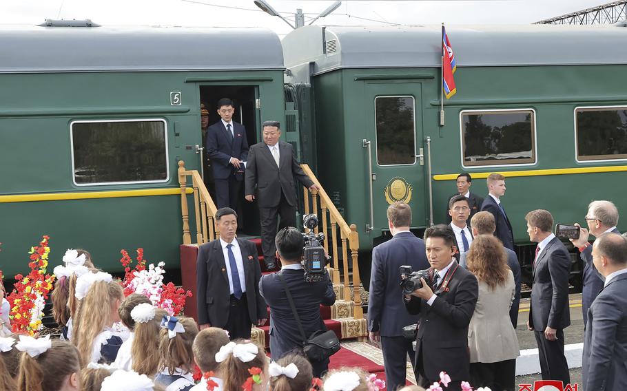 In this photo provided by the North Korean government, North Korean leader Kim Jong Un, center, steps down from his train after arriving in Artyom, near Vladivostok, Russian Far East on Saturday, Sept. 16, 2023. 