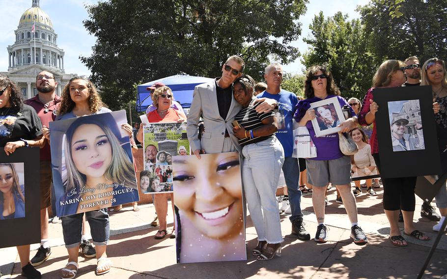 Greg Pixley, a firefighter with the Denver Fire Department, center, comforts Mitchico “Missy” Duff, right center, during a National Fentanyl Prevention and Awareness Day event at the Lincoln Veterans Memorial Park in Civic Center on Aug. 21, 2022, in Denver. Duff lost her 23-year-old daughter Michiko Duff to fentanyl. Duff explained that her daughter thought she was doing cocaine. 