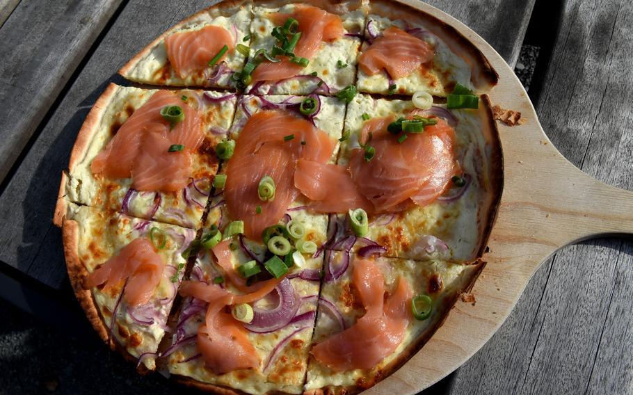 Flammkuchen with slices of smoked salmon and green onions is one of three varieties of the thin-crusted pizzalike dish with creme fraiche available to order at the Seewooghutte, a kiosk with outdoor seating in Ramstein-Miesenbach, Germany. 