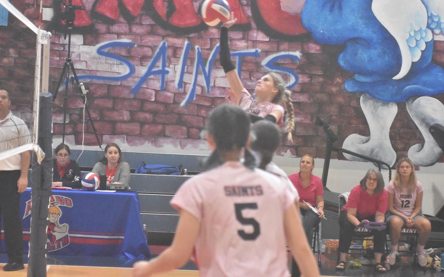 Aviano's Jaycee Spence looks like she might have wings like the Saints' mascot while leaping before taking a swing against the Ansbach Cougars on Saturday, Oct. 15, 2022.