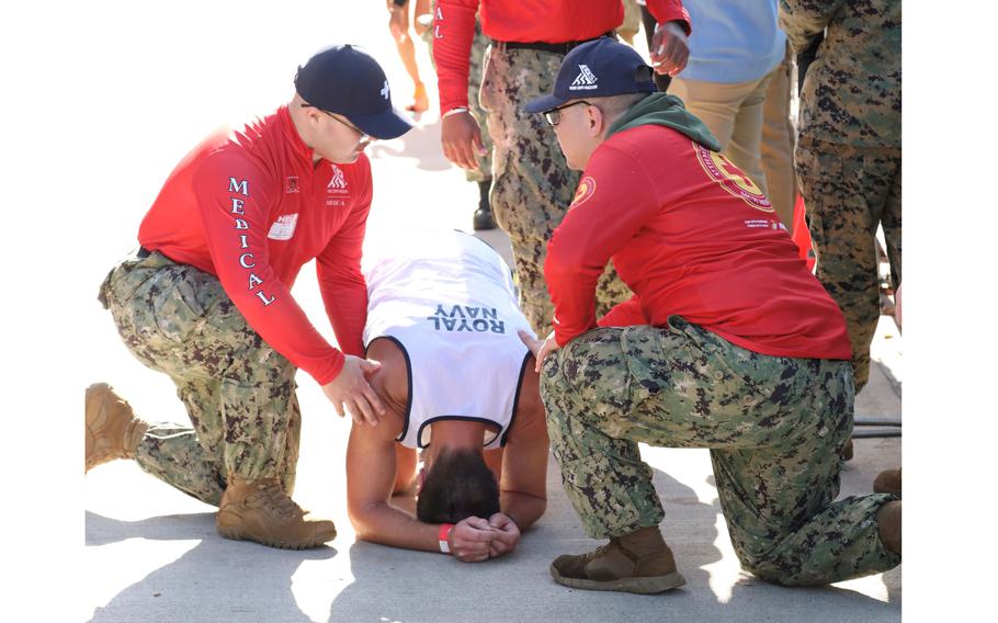 A runner gets assistance after crossing the finish line in the Marine Corps Marathon on Sunday, Oct. 30, 2022, in Arlington, Va.