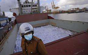 A Sri Lankan port worker stands on a ship that carried emergency supplies granted as humanitarian aid by India government to Sri Lankan people at a port in Colombo, Sri Lanka, Sunday, May 22, 2022.