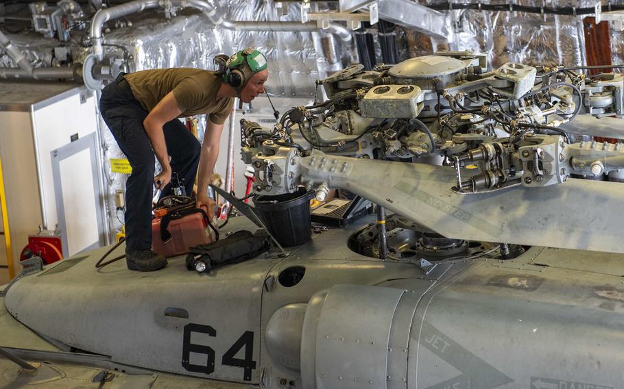 Petty Office 3rd Class David Smerdon pumps hydraulic fluid into one of Helicopter Sea Combat Squadron (HSC) 21's MH-60S Sea Hawk helicopter. Speeding the parts and supplies sailors like him need is the mission of the new Norfolk-based Maintenance Operations Center.