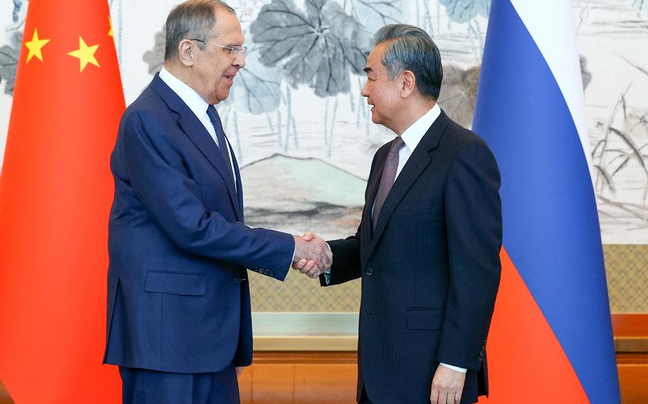 Russia’s Foreign Minister Sergei Lavrov, left, and Director of the Chinese Communist Party Central Committee Foreign Affairs Commission Wang Yi shake hands during a press conference following a meeting in Beijing, April 9, 2024. 