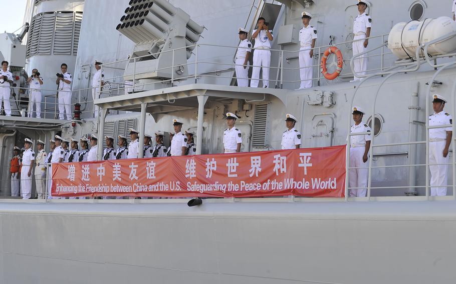 Crew members from China's People's Liberation Army-Navy Luhu-class destroyer Qingdao man the rails as it pulls into Joint Base Pearl Harbor-Hickam, Hawaii, Friday, Sept. 6, 2013.