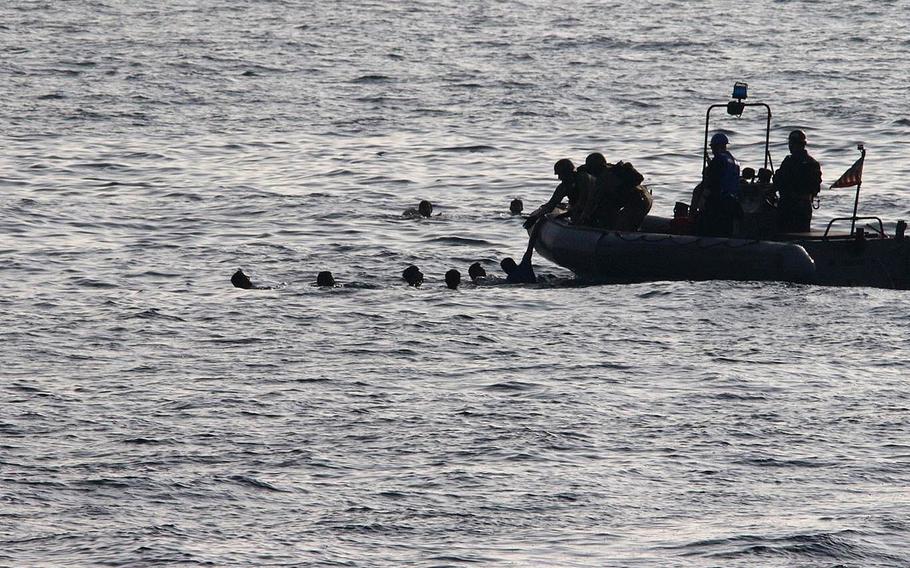 Sailors assigned to patrol coastal ship USS Sirocco rescue mariners in the Gulf of Oman on Oct. 29, 2022. The mariners jumped into the water after setting their vessel on fire as U.S. forces approached, the Navy said.