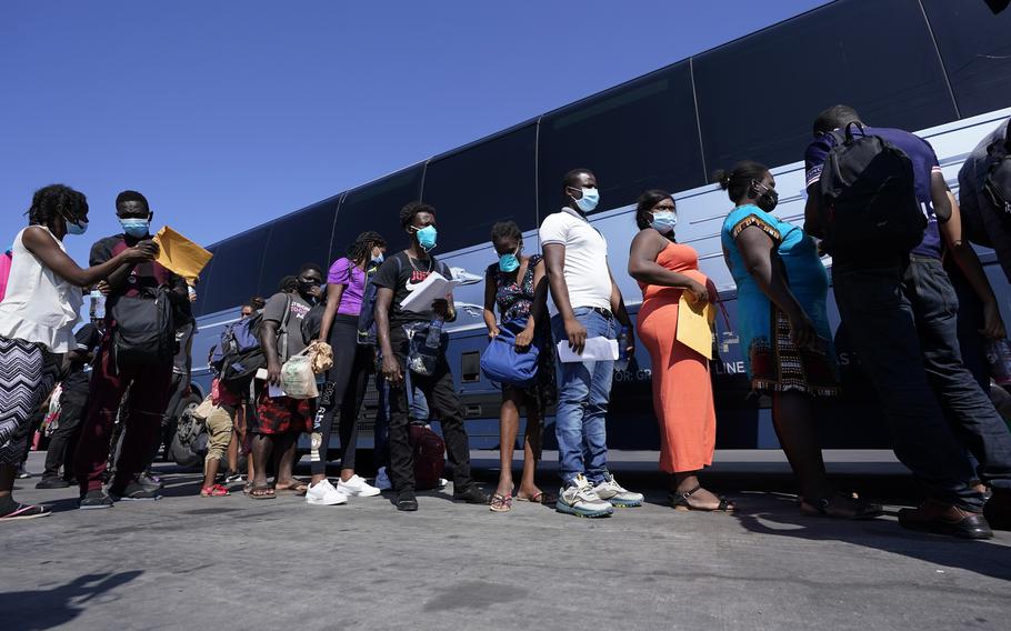 Migrants, many of them from Haiti, board a bus after they were processed and released after spending time at a makeshift camp near the International Bridge, on Monday, Sept. 20, 2021, in Del Rio, Texas. The U.S. is flying Haitians camped at Texas border town back to their homeland and trying to block others from crossing the border from Mexico. 
