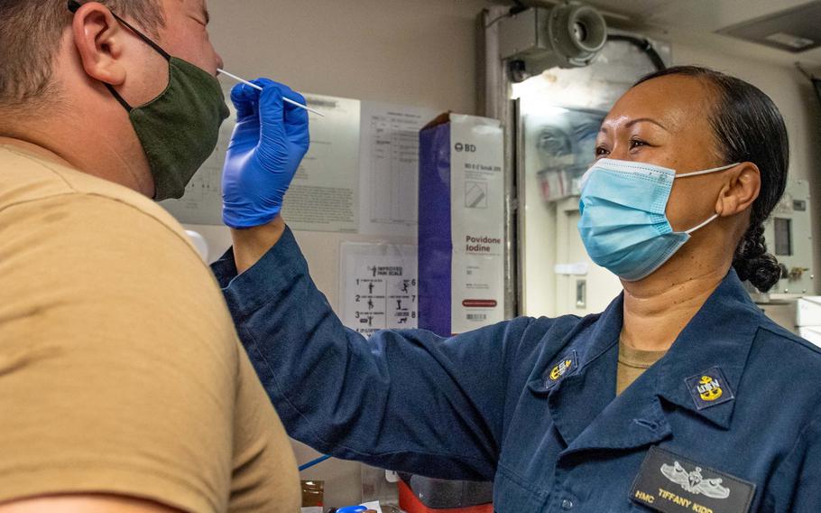 Chief Petty Officer Tiffany Kidd tests for COVID-19 aboard the littoral combat ship USS Charleston at Apra Harbor, Guam, in September 2021. The Navy has ordered commands that have kits available to begin weekly testing of unvaccinated sailors, including those with religious and medical exemptions.