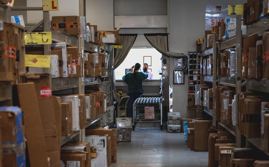 A volunteer postal clerk delivers packages at the Yokota Air Base, Japan, post office on March 11, 2021. 