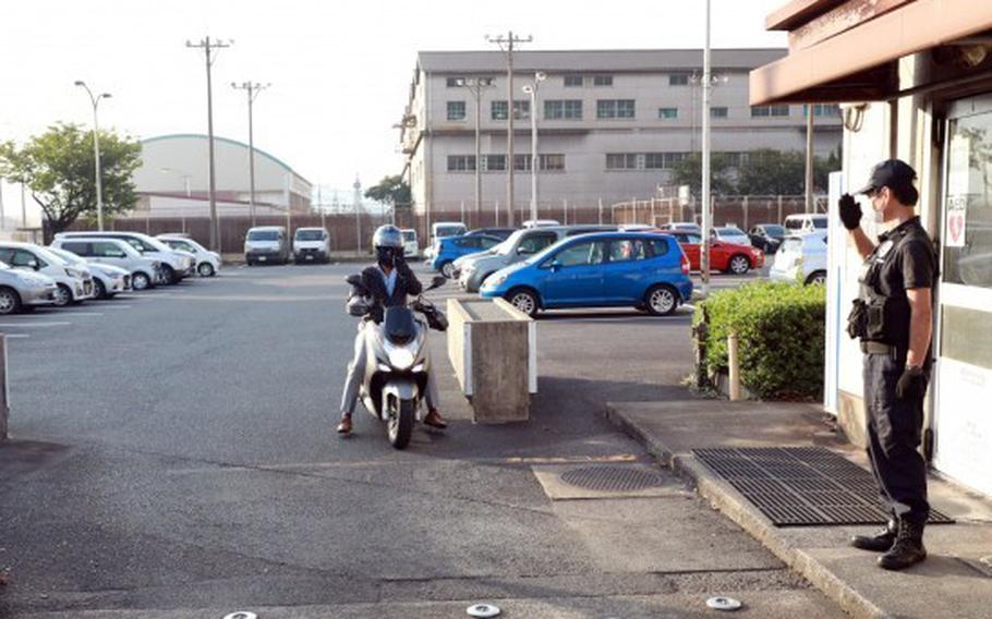 A guard at the U.S. Army’s Kure Pier No. 6 waves through a worker leaving the installation in Hiroshima prefecture, Japan, in 2021. Kure is home to the 10th Support Group, whose mission largely revolves around the stocking, storage and transportation of munitions at three facilities in Kure and one on Okinawa.