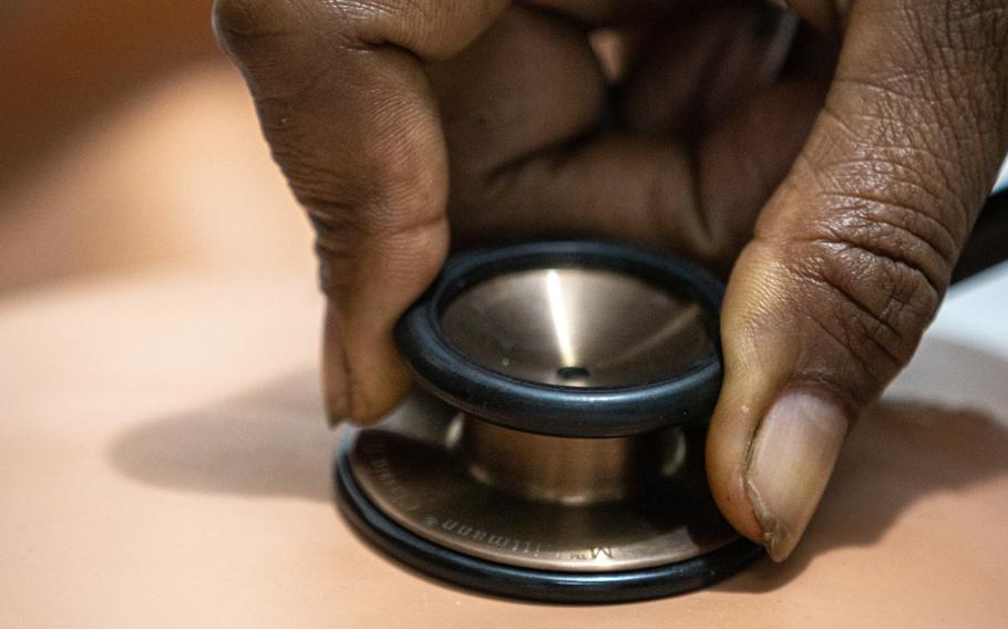 A stethoscope is held to a training dummy’s chest.